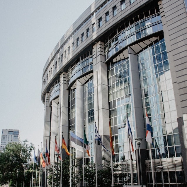 Glasfasad på byggnad i bryssel med flaggor utanför